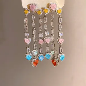 Detail view of colorful heart-shaped zircon tassel earrings in elegant silver