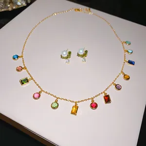 Detailopname van een 14k vergulde halsketting en pareloorbellen sieradensetje.