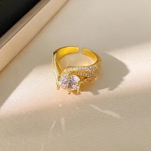 Elegant gold twisted open ring featuring a sparkling central zircon and pavé accents
