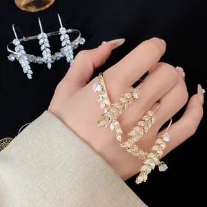 Close-up detail of luxury gold wheat ear wrap ring with sparkling marquise zircons on hand