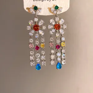 Detailed view of zircon flower tassel earrings on display card with colorful gems
