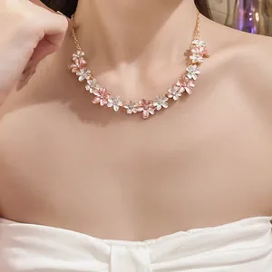 Close-up of a sweet pink and white floral necklace with zircon accents on a model