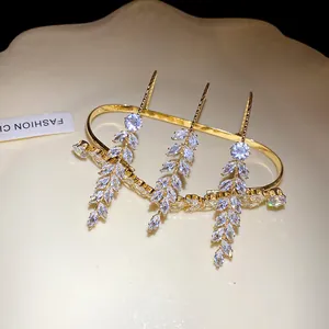Detail view of a gold-finish multi-finger ring with shimmering zircon wheat ear design.