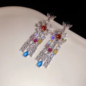 High-quality macro detail of colorful zircon flower earrings with sparkling teardrop tassels.