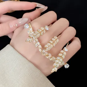Close-up of an exquisite gold wheat ear statement ring with sparkling zircon stones