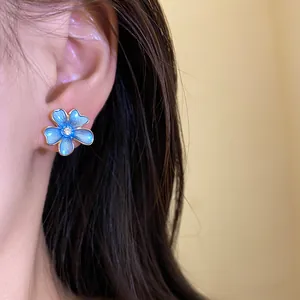 Detailed close-up view of a blue painted flower stud earring featuring a zircon center