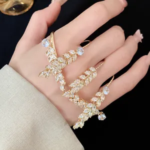 Close-up of fashion zircon wheat ear ring with intricate leaf pattern across fingers