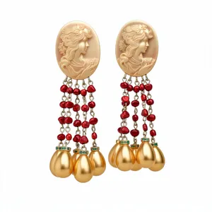 Vintage cameo earrings with red tassel and gold teardrop charms on white background