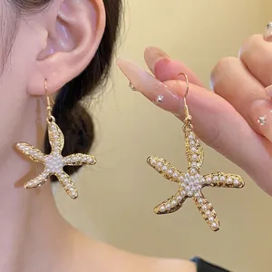 Exquisite goldene Seestern-Ohrhänger mit weißen Perleneinlagen für den Urlaub