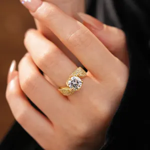 Close-up of golden twisted open ring with sparkling zirconia inlay on a model finger
