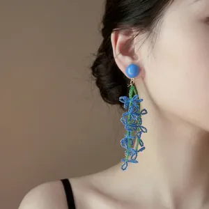 Macro view of elegant blue beaded flower earrings with a cascading floral design
