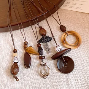 Detailed macro shot of handmade ethnic long necklaces with wood beads and resin pendants