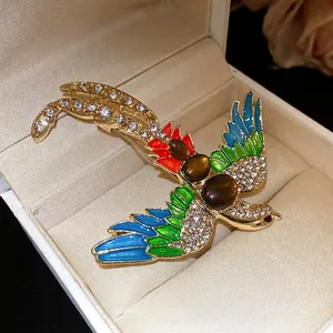 Vintage bird brooch featuring colorful enamel and sparkling rhinestones in a gold finish