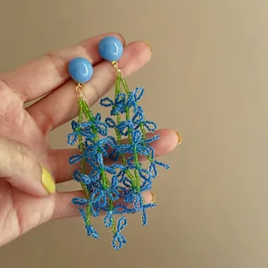 Detailed macro view of seaside style blue handmade beaded flower drop earrings