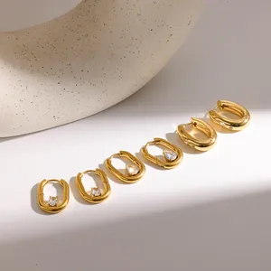 Detailed view of U-shaped gold stainless steel earrings set with sparkling zircons