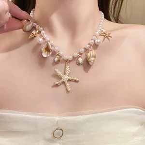 Detaillierte Makroansicht einer Perlenkette mit goldenen Seesternen, Muscheln und Anhängern