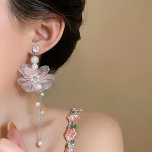 Detaillierte Makroansicht von rosa Chiffon Blumenohrringen mit weißen Perlen