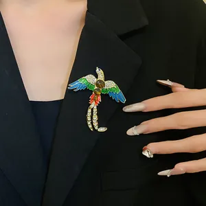 Vintage bird brooch with colorful enamel and sparkling rhinestones on a black blazer.
