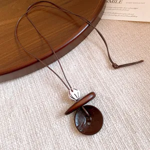 Detail view showing the intricate texture of the ethnic style resin and wood pendant.