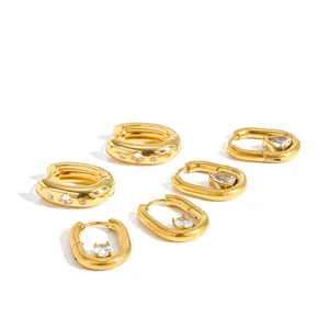 Macro view of gold stainless steel U-shaped earrings with sparkling zircon inlays