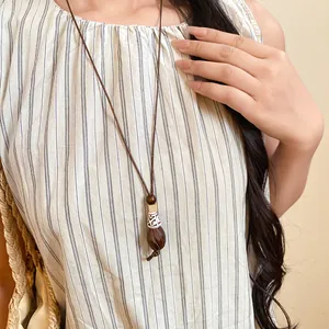 Detail shot of a long vintage ethnic style necklace with a wood and resin pendant