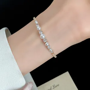 Close-up of elegant 18k gold plated pearl and zircon bracelet on wrist