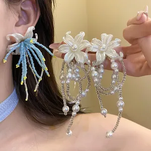 Macro view showing intricate details of white and blue floral pearl tassel earrings