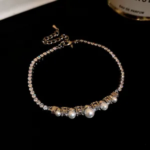 Close-up of 18k gold plated bracelet with sparkling zircons and elegant white pearls