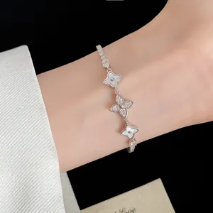Exquisite 18k gold plated bracelet with zircon flower charms worn on a female wrist