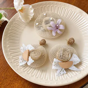 Detail shot of handmade straw hat earring and brooch set with floral and lace accents