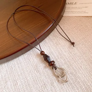 Close-up detail of ethnic style long necklace featuring wood beads and silver interlocking rings