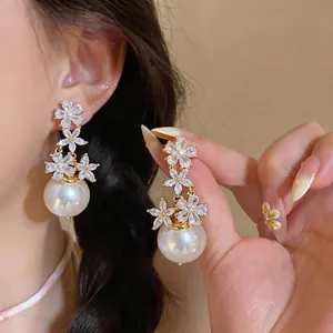 Elegant French style earrings featuring zircon flowers and large white pearls for women.