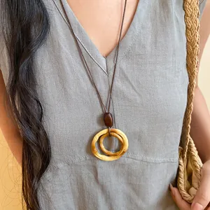 Close-up of a retro ethnic style long necklace with round resin wood-texture pendant.