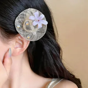 Close-up of woven straw hat style earring with purple cloth flower and rhinestone details