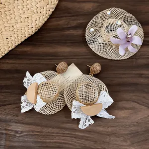 Detail view of handmade rope woven straw hat earrings with lace and floral brooch