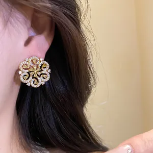 Close-up detail of a gold filigree flower earring with sparkling pave crystals.