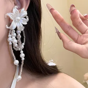 Close-up detail showing the elegant pearl flower tassel earrings worn on a model's ear