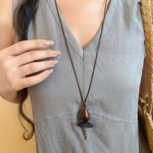 Close-up detail of a retro ethnic long necklace with a wooden bead and woven pendant charm