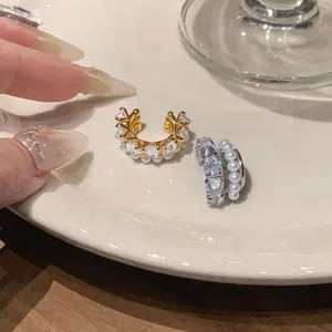 Detailed view of luxury multi-layer pearl and zircon ear cuffs in gold and silver finish