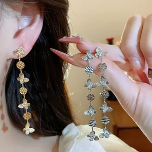 Close-up of 18k gold plated butterfly tassel earrings with zircon on an Asian model.