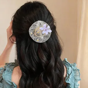 Detail shot of a mini straw hat hair clip with lavender flower and rhinestones on model