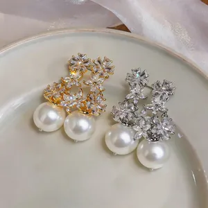 Exquisite close-up detail of gold and silver floral drop earrings with crystals and pearls