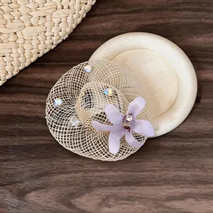Close-up detail of the woven straw hat earring with purple flower and rhinestones.