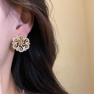 Detailed view of elegant gold hollow flower stud earrings with sparkling micro diamonds.