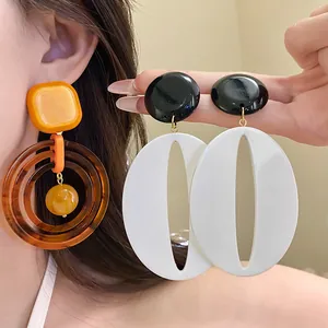 Macro view of vintage resin geometric drop earrings in Maillard brown and black white colors