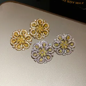 Detailed macro view of French style flower hollowed stud earrings with yellow stones