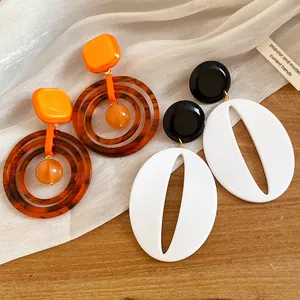 Detail view of retro resin drop earrings in Maillard brown and black-white styles