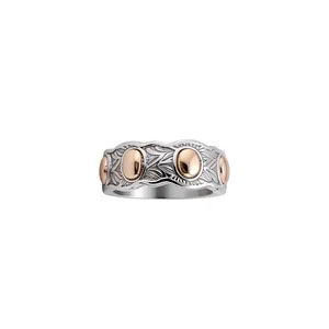 Elegante anillo ondulado bicolor con grabados de hojas y detalles en oro rosa