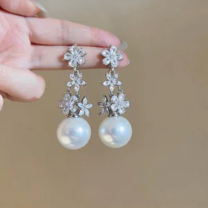 Elegant floral drop earrings featuring sparkling zircons and large white pearls