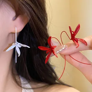Close-up of elegant metal spray-painted flower ear hooks in white and red finish